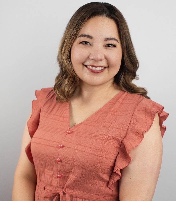 Meet Our Team - Professional and Welcoming Group at a Conference Table Faces the Camera, Team Leader Sitting on the Table with Arms Folded